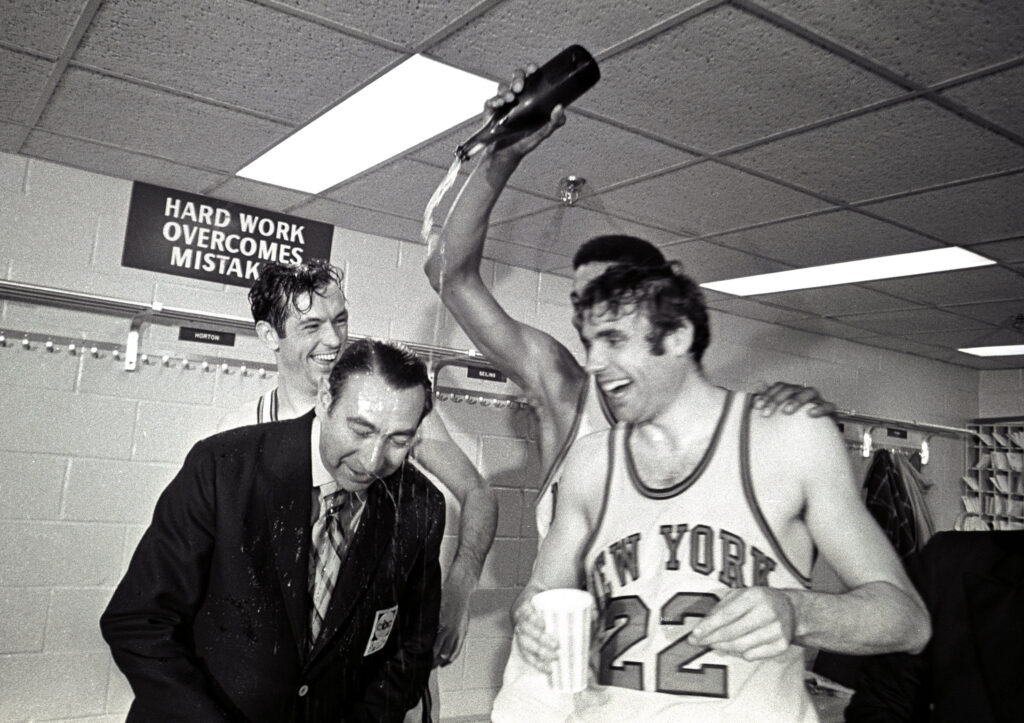 May 8, 1970: The Knicks defeat the Lakers 113-99 in Game 7 of the 1970 NBA Finals at Madison Square Garden. Dave DeBusschere and Bill Bradley celebrate their championship triumph over by pouring champagne on ABC announcer Howard Cosell.